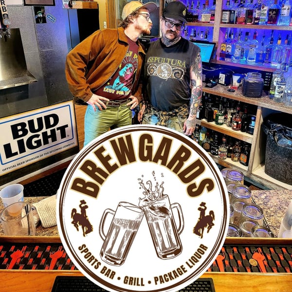 Two men pose playfully in front of a well-stocked bar at Brewgards Lounge, with the logo overlaid.
